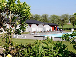 <b>privat Sommerhus og feriehus udlejning på syd Bornholm </b>
- Ferielejlighed beliggende i det smukt kuperede landskab uden for Åkirkeby på Bornholm.
Flot lejlighed i udkanten af hyggelige Åkirkeby med butikker, restauranter m.m. Lejligheden er en del af feriestedet Dams på Bakken, som bl.a. byder på stor udendørs swimmingpool med lav ende, stor trampolin, gynger og fodboldbane.
Lejligheden har en hyggelig opholdsstue med TV/DVD og radio/cd. Åben køkkenafdeling med bl.a. miniovn, køleskab, fryser, elkomfur (2 plader), emhætte og spiseplads. Badeværelse med DU/WC og gulvvarme. To værelser. Udgang til egen terrasse med markise, havemøbler og grill.
Kun 10 m til poolen. Lige ved siden af ligger oplevelsescenteret NaturBornholm. 4,5 km. væk finder man dejlige sandstrande. Fine muligheder for vandreture samt leg og boldspil lige uden for døren.
Røgfri lejlighed og ingen husdyr. <b>privat Sommerhus og feriehus udlejning på syd Bornholm </b>
- Dams på Bakken - dør 8
